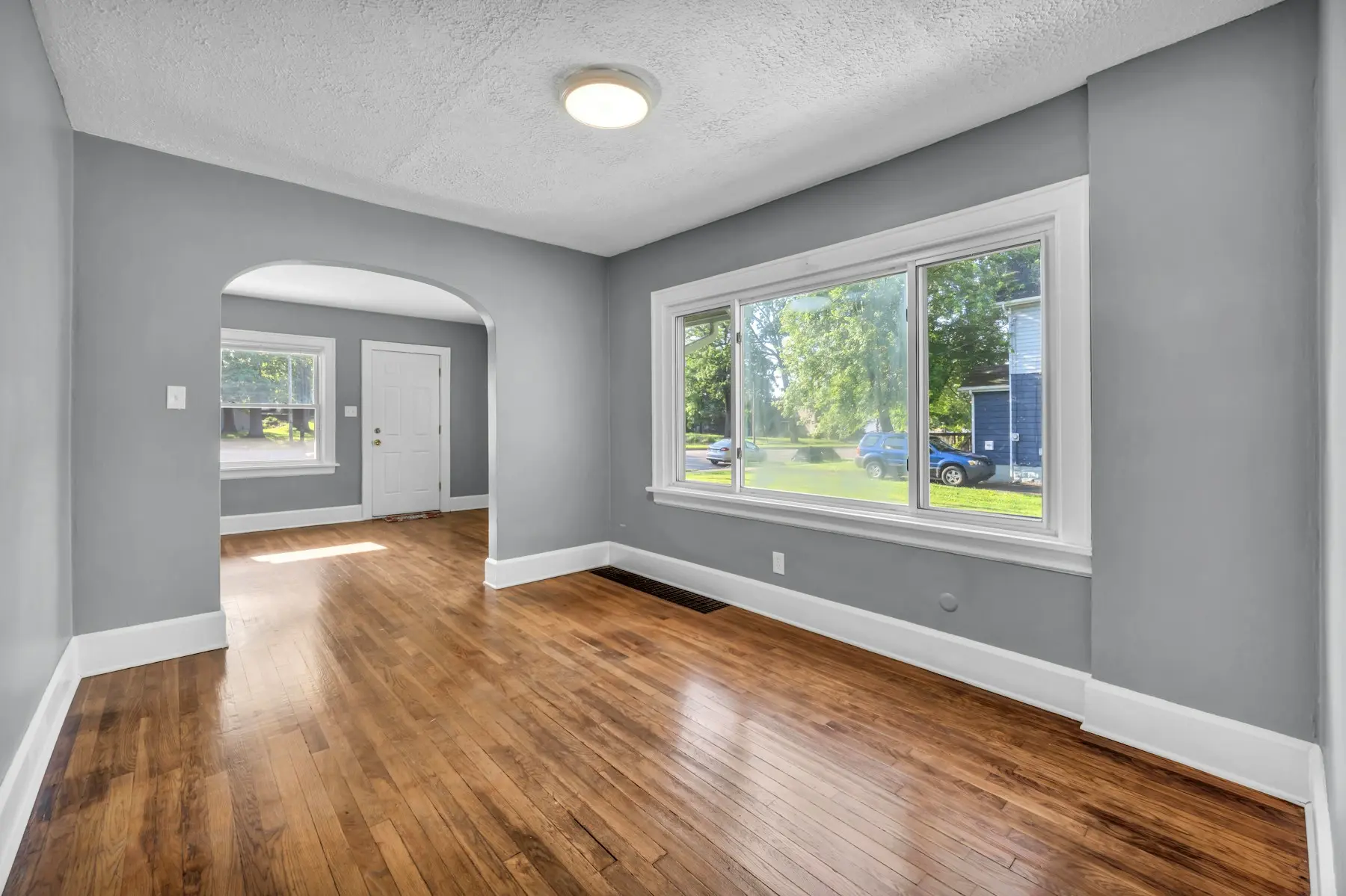 Living room with freshly painted gray walls and refinished hardwood
