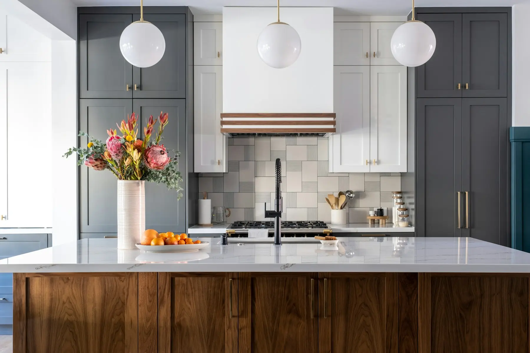 Walnut kitchen island with white quartz top and tiled backsplash