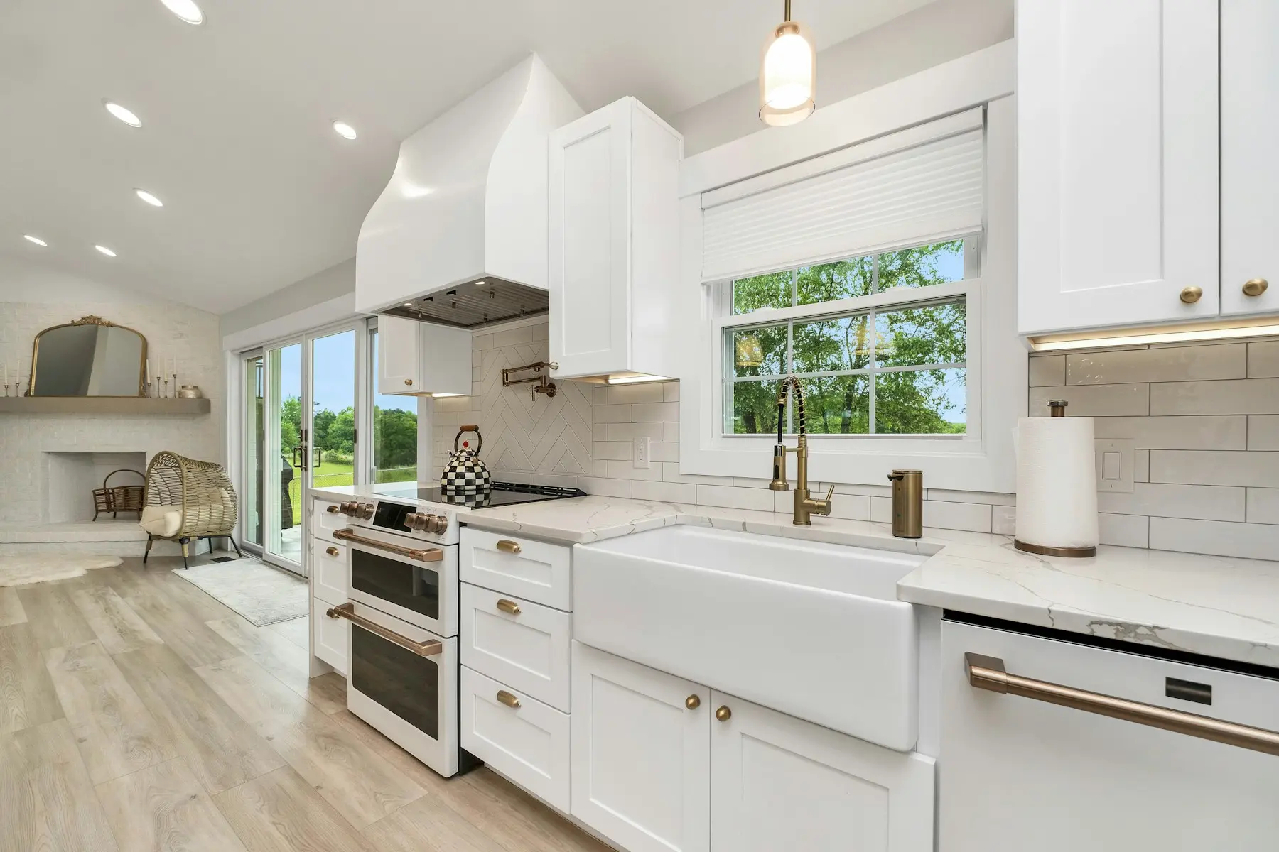 Farmhouse sink under a window in a white shaker kitchen